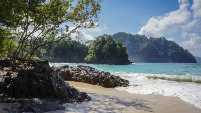 Tropischer Strand mit Felsen und türkisfarbenem Wasser