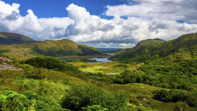 Grüne Hügel und ein See prägen die Landschaft im Killarney Nationalpark.