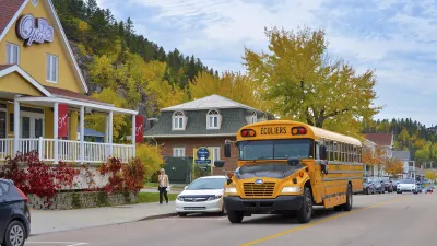 Gelber Schulbus fährt auf einer Straße in einer Stadt.
