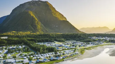 Campingplatz am Fluss mit Bergen im Hintergrund