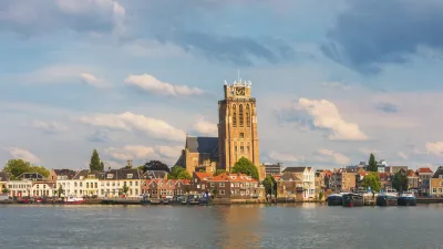 Historischer Kirchturm dominiert die Skyline von Dordrecht am Flussufer.