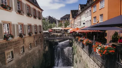 Wasserfall fließt zwischen bunten Fachwerkhäusern in Saarburg.