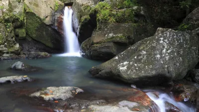 Wasserfall stürzt in ein ruhiges Becken im grünen Regenwald