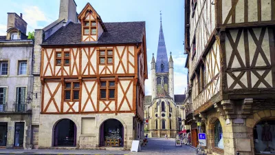 Historische Fachwerkhäuser säumen die Straße zur Notre-Dame Kirche in Dijon.