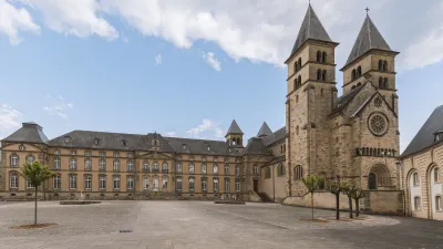 Historische Kirche mit zwei Türmen und einem Platz davor.