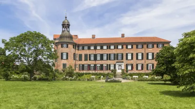 Eutiner Schloss mit rotem Backstein und markantem Turm steht im Grünen