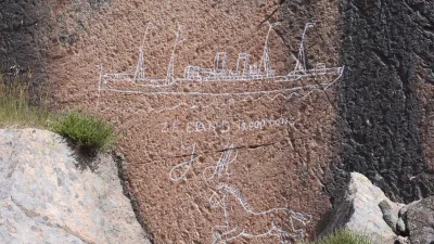 Felsgravuren zeigen ein Schiff und ein Pferd auf einem Felsen.