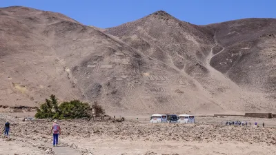 Historische Salpeterminen in der Atacamawüste mit Wanderern und Fahrzeugen.