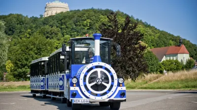 Blaue Ludwigsbahn fährt vor einer Burg auf einem Hügel