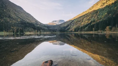 Spiegelung der Berge im ruhigen See bei Sonnenuntergang