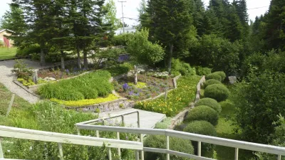 Blühender Garten mit kunstvoll geschnittenen Büschen und bunten Blumenbeeten.