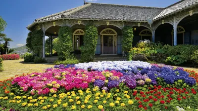 Blühende Blumen vor einem historischen japanischen Gebäude.