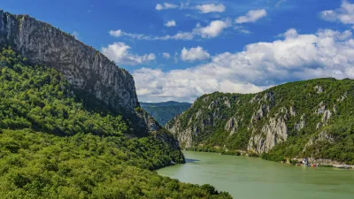 Donau fließt durch eine grüne Schlucht mit steilen Felswänden.