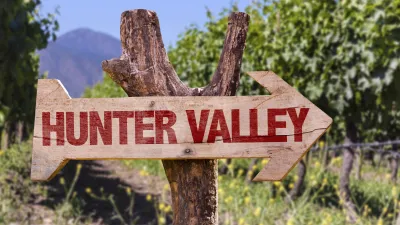 Holzschild mit der Aufschrift "Hunter Valley" in einem Weinberg.