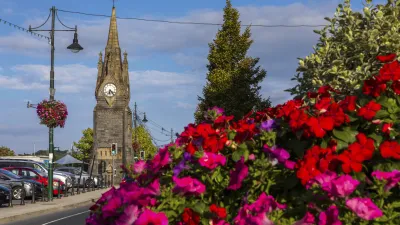 Historischer Uhrturm mit blühenden Blumen im Vordergrund