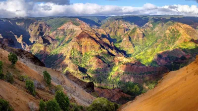 Der Waimea Canyon auf Hawaii zeigt eine beeindruckende Landschaft mit roten Felsformationen und grüner Vegetation.