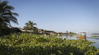 Ein rotes Boot fährt auf dem Wasser einer Lagune vorbei.