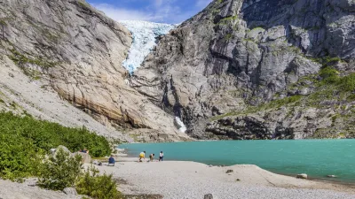 Wanderer genießen die Aussicht auf den Gletscher und den türkisfarbenen See.