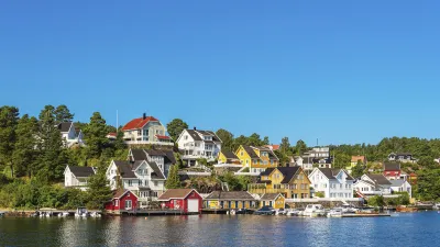 Bunte Holzhäuser am Ufer eines norwegischen Fjords.