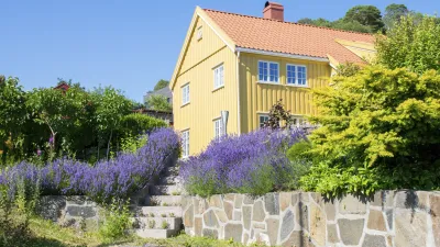Gelbes Holzhaus mit blühendem Lavendel im Garten