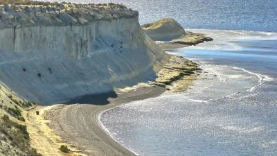 Küstenlandschaft mit Strand und Felsen am Meer.