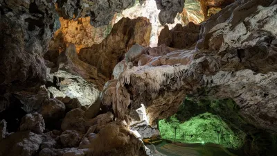 Tropfsteinhöhle mit grünem Licht und Felsformationen