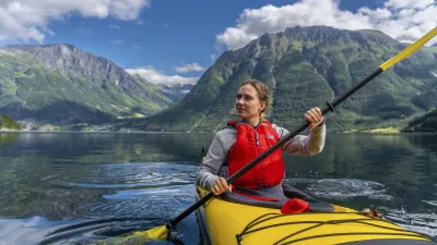 Kajakfahrerin paddelt auf dem Nordfjord in Norwegen.