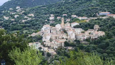 Korsisches Bergdorf mit weißen Häusern und einer Kirche.