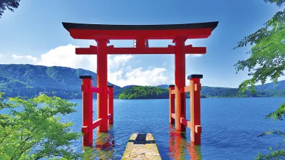 Rotes Torii-Tor steht im Wasser vor einer Berglandschaft