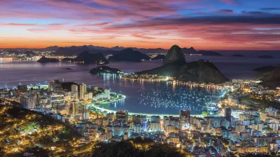 Rio de Janeiro bei Nacht mit beleuchteter Stadt und Zuckerhut.