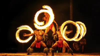 Feuertänzer schwingen flammende Reifen bei einer hawaiianischen Luau-Feier.
