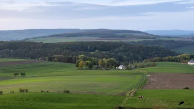 Grüne Hügellandschaft mit Feldern und Wäldern in der kleinen Schweiz.