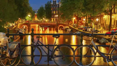 Amsterdam bei Nacht mit Fahrrädern am Kanal