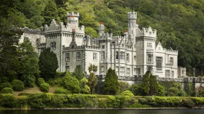 Kylemore Abbey, ein Schloss in Irland, liegt idyllisch am See.