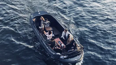 Eine Gruppe von Menschen fährt mit einem kleinen Boot auf dem Meer.