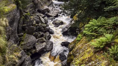 Wilder Wasserfall stürzt durch einen felsigen Canyon in Tasmanien.
