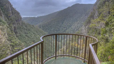Aussichtsplattform mit Blick auf eine grüne Canyonlandschaft