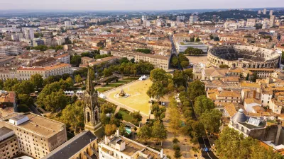 Luftaufnahme von Nîmes mit römischem Amphitheater und grüner Stadtlandschaft