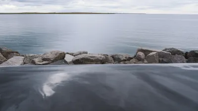 Gezeitengestein am Ufer eines ruhigen, grauen Ozeans.