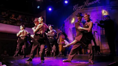 Tänzerpaar in traditioneller Kleidung führt leidenschaftlichen Tango auf.