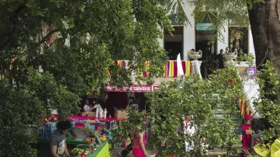 Verkäufer bieten Waren an einem belebten Markt im Freien an.