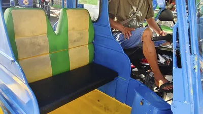 Mann sitzt im Fahrersitz eines blauen Trikes auf den Philippinen.