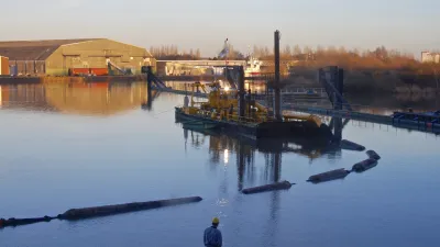 Arbeitsschiff verlegt Rohre im Wasser vor der Werft.
