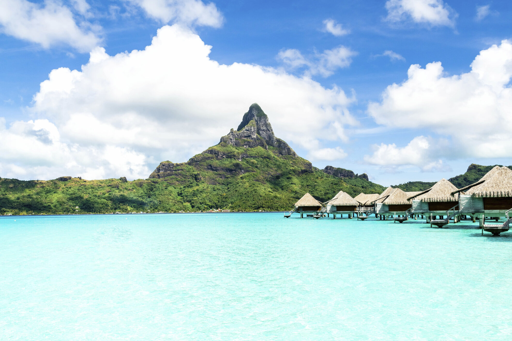 Hütten in türkis leuchtendem Wasser auf Moorea, Fanzösisch Polynesien