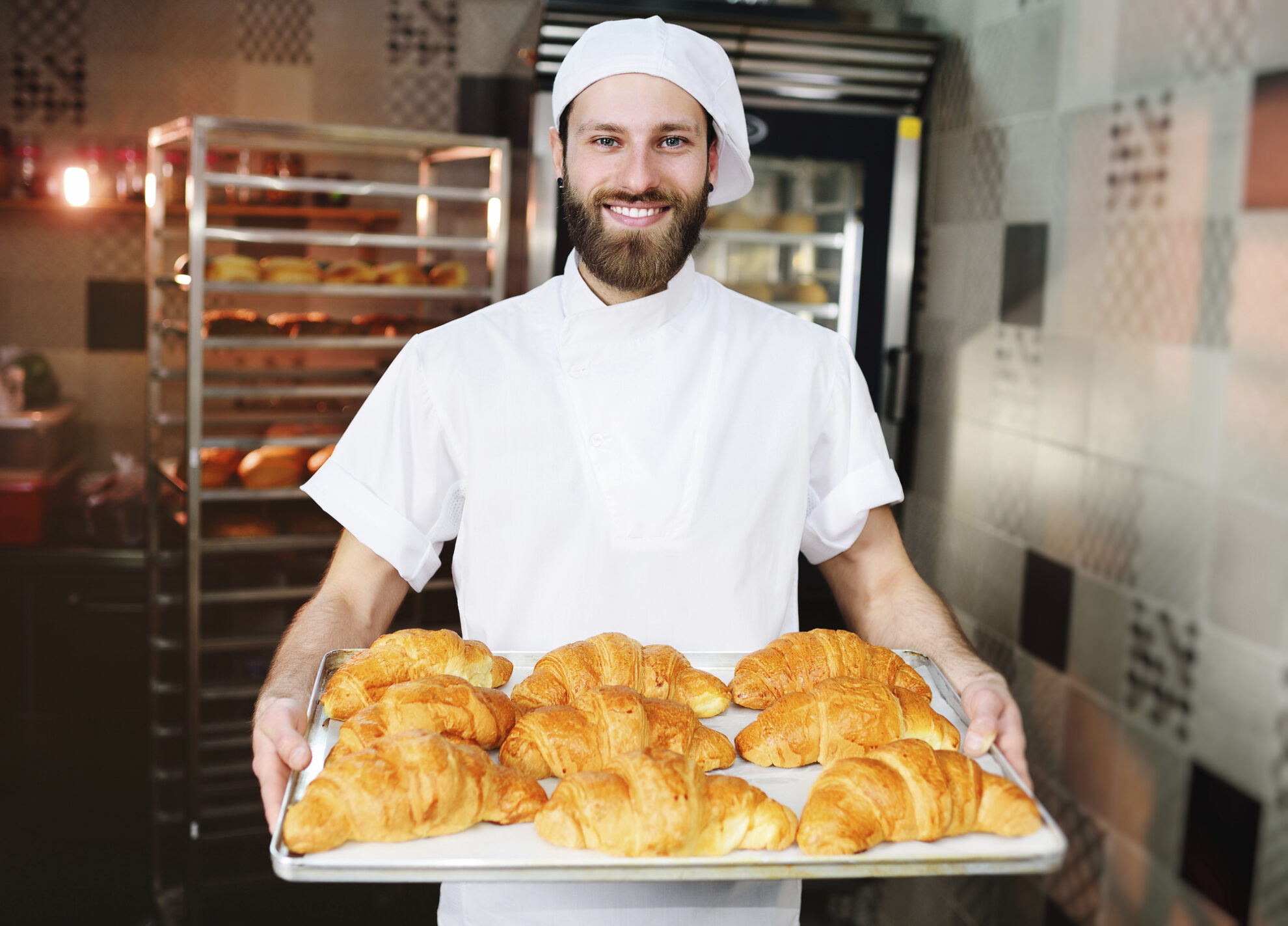Französischer Bäcker mit Croissants auf einem Tablett