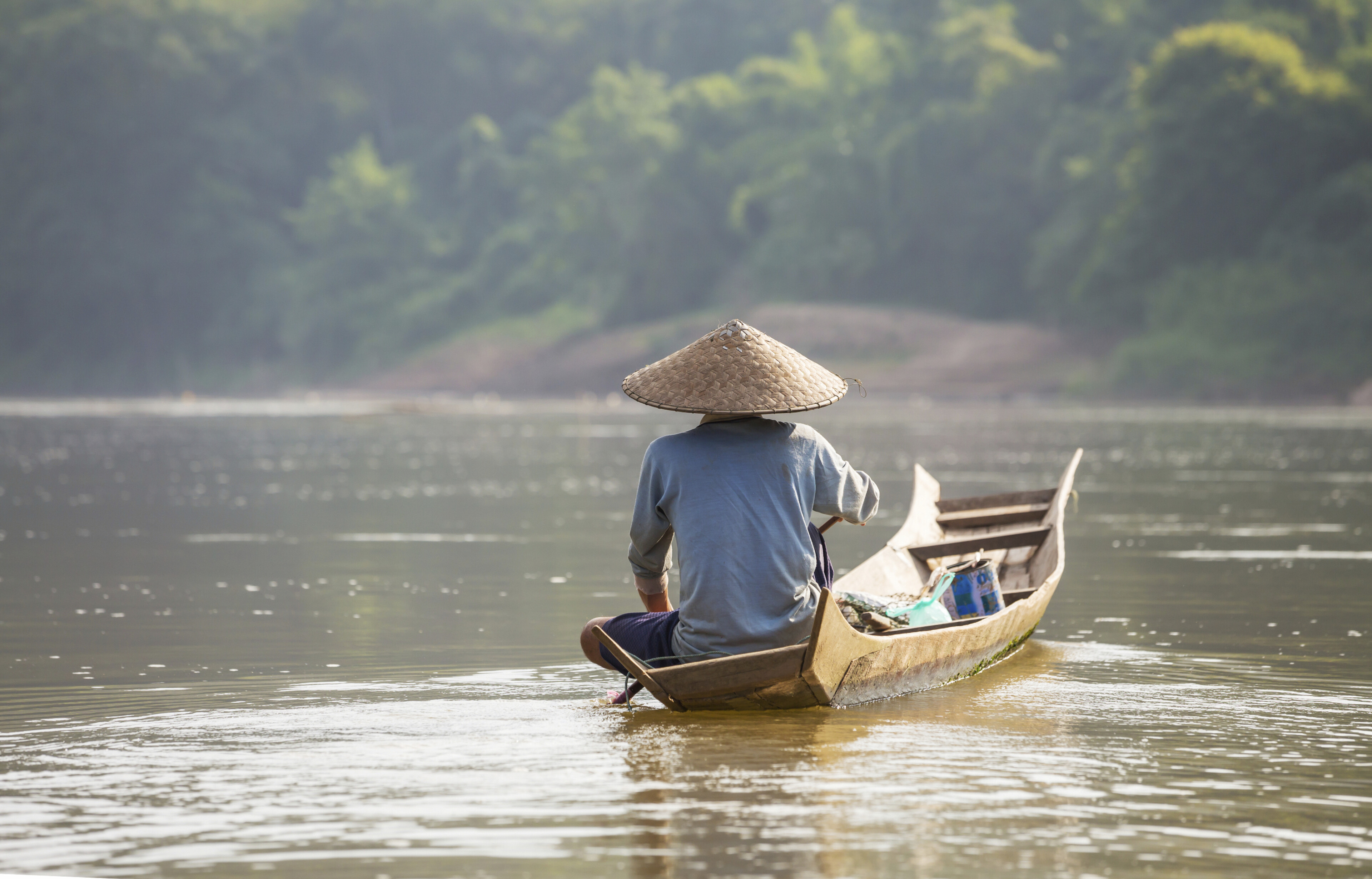 Einheimischer auf einem Holzboot in der Provinz Luang Prabang, Laos